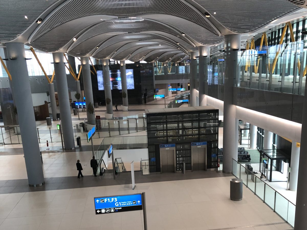 Arriving passengers walk above the departure sections